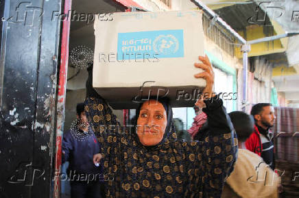 Palestinians receive aid following a ceasefire between Israel and Hamas, in Khan Younis in the southern Gaza Strip