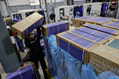 Workers handle boxes of flowers for export before Valentine?s Day, in Quito