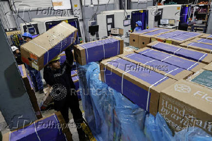 Workers handle boxes of flowers for export before Valentine?s Day, in Quito