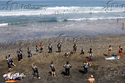 A group of tourists attend a surf class on Las Canteras Beach in Las Palmas de Gran Canaria