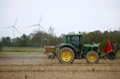A farmer drives his tractor as he works in his field in Vieillevigne