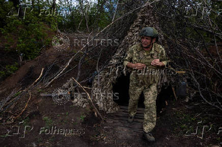 A Ukrainian serviceman of the 22nd Separate Mechanised Brigade leaves a dugout at an artillery position on the outskirts of Chasiv Yar
