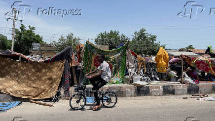 People take refuge along an expressway after relief camps reached maximum capacity in Maiduguri