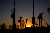 Workers repair a power line damaged by Eaton Fire in Altadena