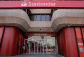 A woman uses an ATM machine at a Santander bank branch office in Malaga