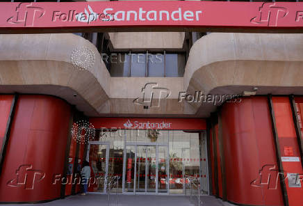 A woman uses an ATM machine at a Santander bank branch office in Malaga