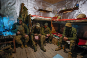 Ukrainian servicemen rest inside a dugout at their position in a front line in Donetsk region