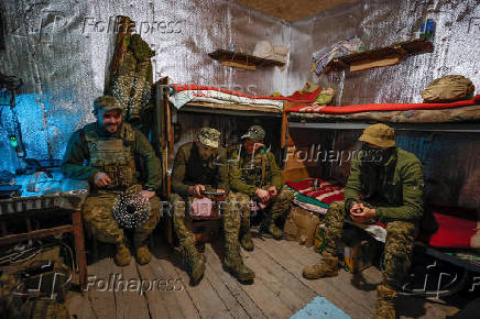 Ukrainian servicemen rest inside a dugout at their position in a front line in Donetsk region