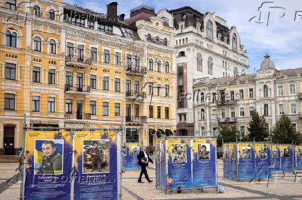 A man walks between memorial placards honouring fallen Ukrainian service members on St Sophia Square in central Kyiv