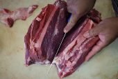 A butcher cuts a piece of meat at a butcher shop in Rio de Janeiro