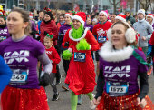 Runners wearing Santa Claus-themed outfits take part in the 