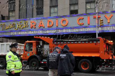 Officers from the New York City Police Department (NYPD) stand guard beside trucks from the New York City Department of Sanitation outside Radio City Music Hal
