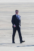 Tesla CEO and X owner Elon Musk walks on the tarmac