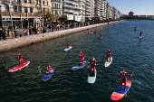 Members of the ThesSUP team wearing Santa Claus costumes paddle off the seafront of Thessaloniki