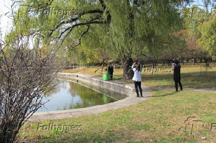 Casal de noivos posa para fotos em lago de hospedaria em Pyongyang