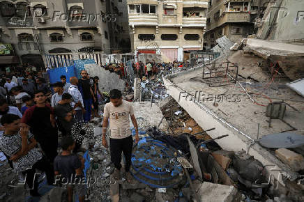 Palestinians gather at a UN school sheltering displaced people, following an Israeli strike, amid Israel-Hamas conflict, in Gaza City