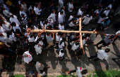 Catholic devotees carry a holy cross at a street parade during the Holy Friday Passion of the Lord Celebrations in Colombo