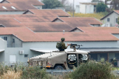 Israeli military vehicles drives near Kibbutz Zikim, in Israel