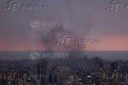 Smoke rises in Beirut's southern suburbs during sunset, after Israeli air strikes, amid ongoing hostilities between Hezbollah and Israeli forces, as seen from Sin El Fil