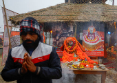 A man prays to deceased Mahant Triveniji, a Sadhu or a Hindu Holy man, whose body was kept for devotees and other holy men to pay their respects before the last rites during the 