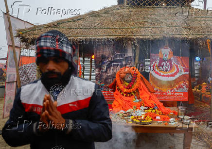 A man prays to deceased Mahant Triveniji, a Sadhu or a Hindu Holy man, whose body was kept for devotees and other holy men to pay their respects before the last rites during the 