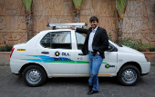 FILE PHOTO: Bhavish Aggarwal, CEO and co-founder of Ola, an app-based cab service provider, poses in front of an Ola cab in Mumbai