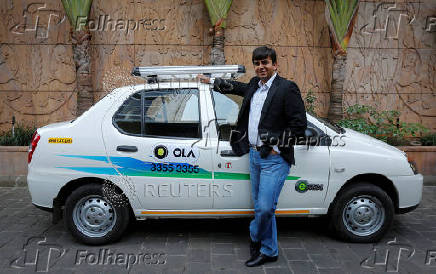 FILE PHOTO: Bhavish Aggarwal, CEO and co-founder of Ola, an app-based cab service provider, poses in front of an Ola cab in Mumbai