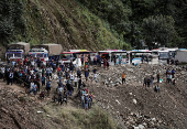 Rescue personnel work to retrieve the bodies of the victims from a landslide triggered by heavy rainfall in Dhading