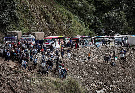 Rescue personnel work to retrieve the bodies of the victims from a landslide triggered by heavy rainfall in Dhading