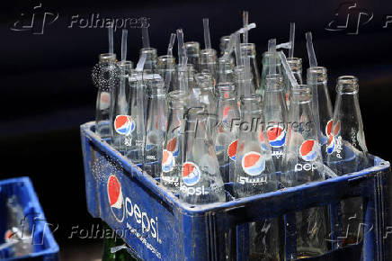 Crate full of empty bottles of Pepsi placed outside a cafe to be picked by supply truck in Karachi