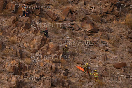 Rescue personnel carry the body of an agent of the National Institute of Migration (INM), in Ciudad Juarez