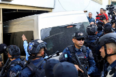 Police officers escort a van allegedly transporting former Honduran Joint Chief of Staff Gen. Romeo Vasquez