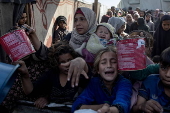 Displaced Palestinians collect donated food in Khan Yunis, southern Gaza