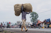 Internally displaced civilians from the camps in Munigi and Kibati, carry their belongings as they flee to Goma