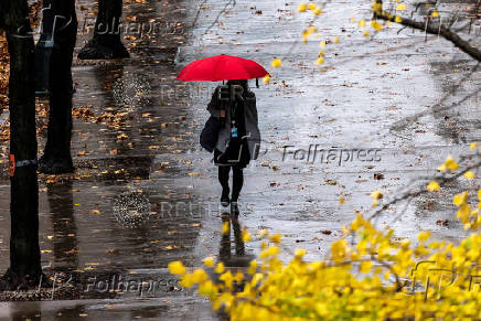 A woman walks in a local street during a rainy day in New York