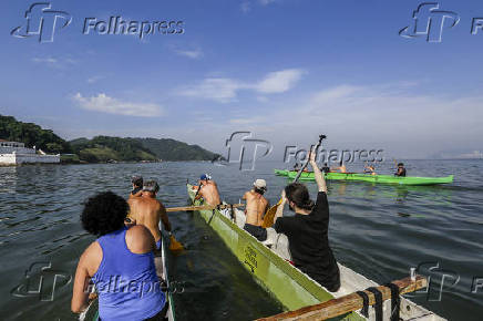 Alunos da escola Canoagem Caiara remam em canoa havaiana
