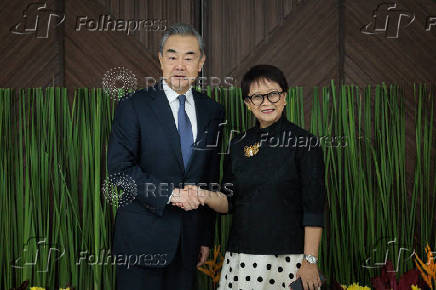 Chinese Foreign Minister Wang Yi and Indonesian Foreign Minister Retno Marsudi shake hands during their meeting in Jakarta