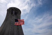 FILE PHOTO: The US flag flies at half mast in front of a coal-fired power plant's cooling tower at Duke Energy's Crystal River Energy Complex