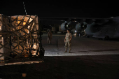 A Lebanese military member stands while palettes of aid for Lebanon delivered by United Arab Emirates is being moved, at Beirut International Airport,