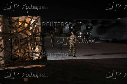 A Lebanese military member stands while palettes of aid for Lebanon delivered by United Arab Emirates is being moved, at Beirut International Airport,