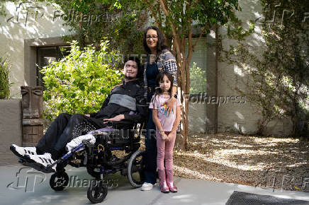 First-time voter Yeshua Loya, 21, his sister Hadassah, 7, and mom Mariana Sanchez pose for a portrait at The Plaza assisted living facility, in Scottsdale