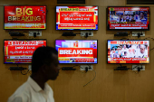 An official stands in front of television screens inside the media monitoring room ahead of India's general election, at the Office of the Chief Electoral Officer, Bengaluru