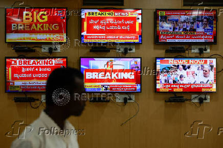 An official stands in front of television screens inside the media monitoring room ahead of India's general election, at the Office of the Chief Electoral Officer, Bengaluru