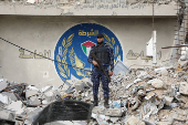 Palestinian Hamas policemen keep guard at their destroyed headquarters in Gaza City