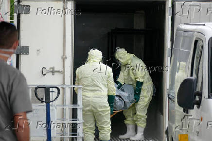 Funcionrio do hospital Joo Lcio retira corpo de paciente morto, em Manaus