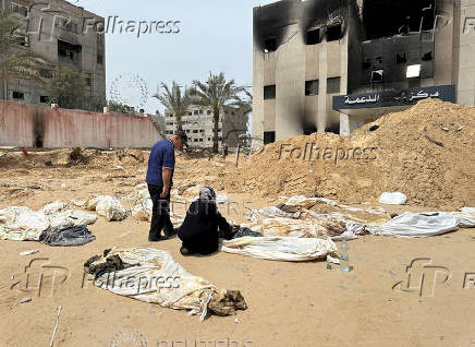 FILE PHOTO: People work to recover the bodies of Palestinians killed during Israel's military offensive and buried at Nasser hospital, in Khan Younis