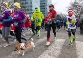 Runners wearing Santa Claus-themed outfits take part in the 