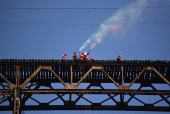 Guatemalan firefighter dressed as Santa Claus rappels down the Vacas Bridge to give toys to children, in Guatemala City