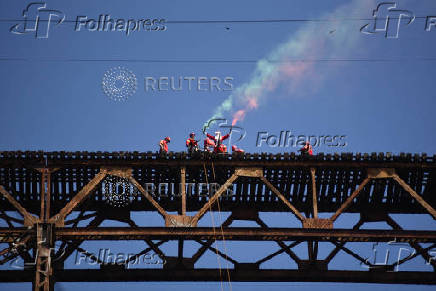 Guatemalan firefighter dressed as Santa Claus rappels down the Vacas Bridge to give toys to children, in Guatemala City