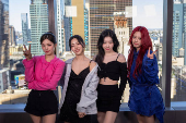 Members of the group Itzy pose in front of the Manhattan skyline during an interview with Reuters in New York